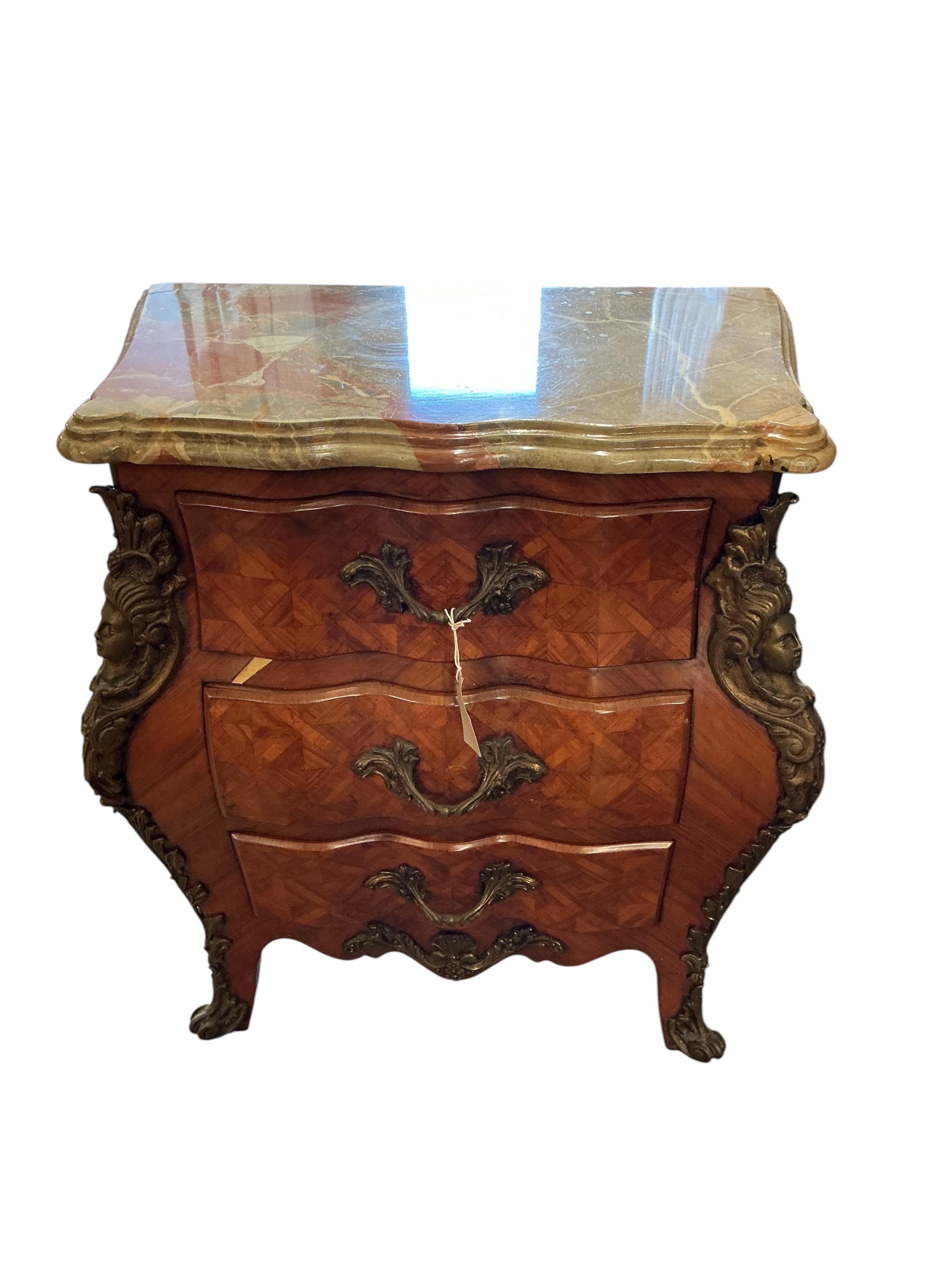 A pair of French transitional style bombe gilt metal mounted onyx top three drawer bedside chests, width 61cm, depth 33cm, height 71cm